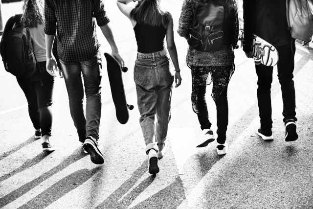 grayscale photography of five people walking on road